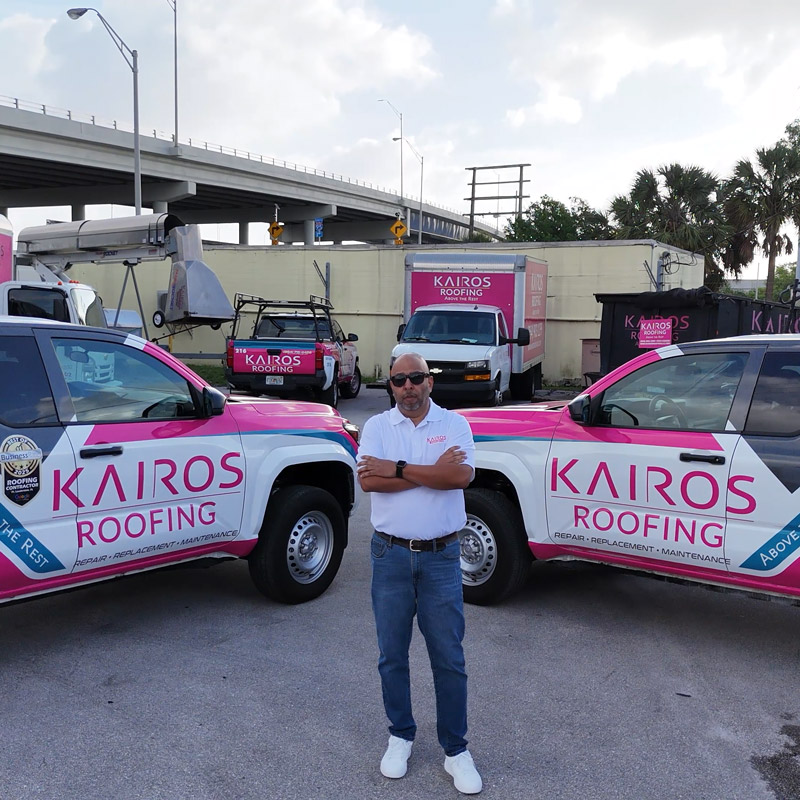 Kairos Roofing owner in front of branded vehicles